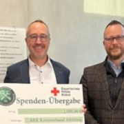 Die Geschäftsführung der Nürnberger Wach- und Schließgesellschaft übergibt eine Spende an den BRK-Kreisverband Altötting. Die Mittel fließen direkt in die Katastrophenschutzhalle